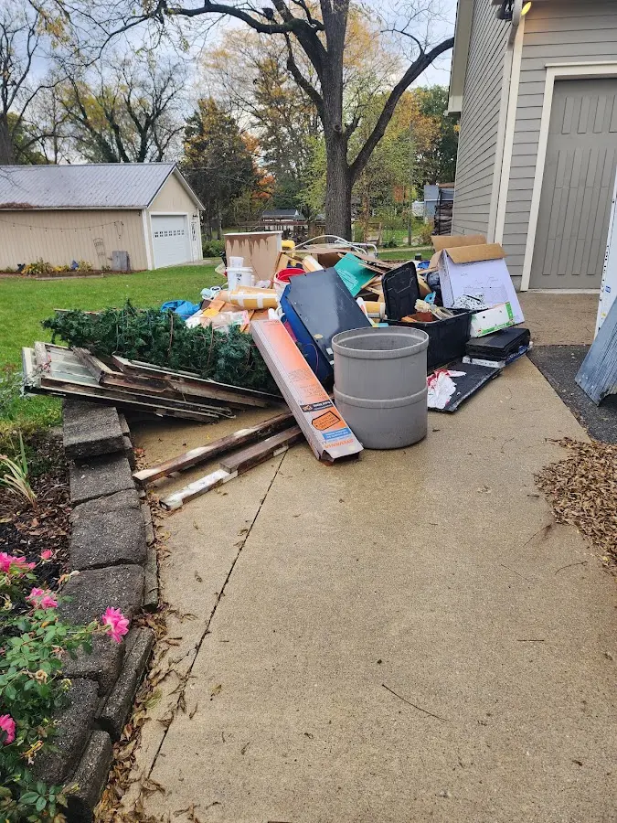 Dumpster being loaded with debris for 12 Yard Dumpster Rental in Cadillac
